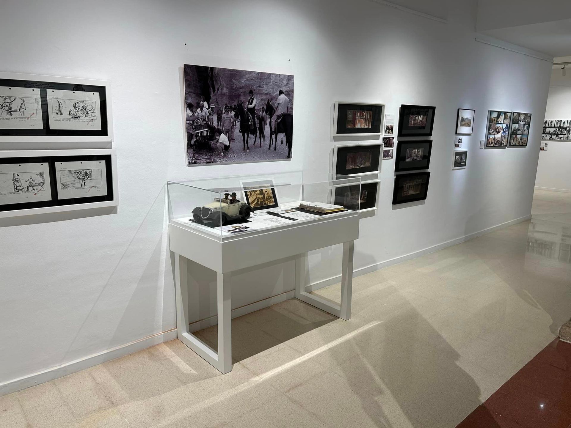 Una vitrina en un museo con cuadros en la pared.