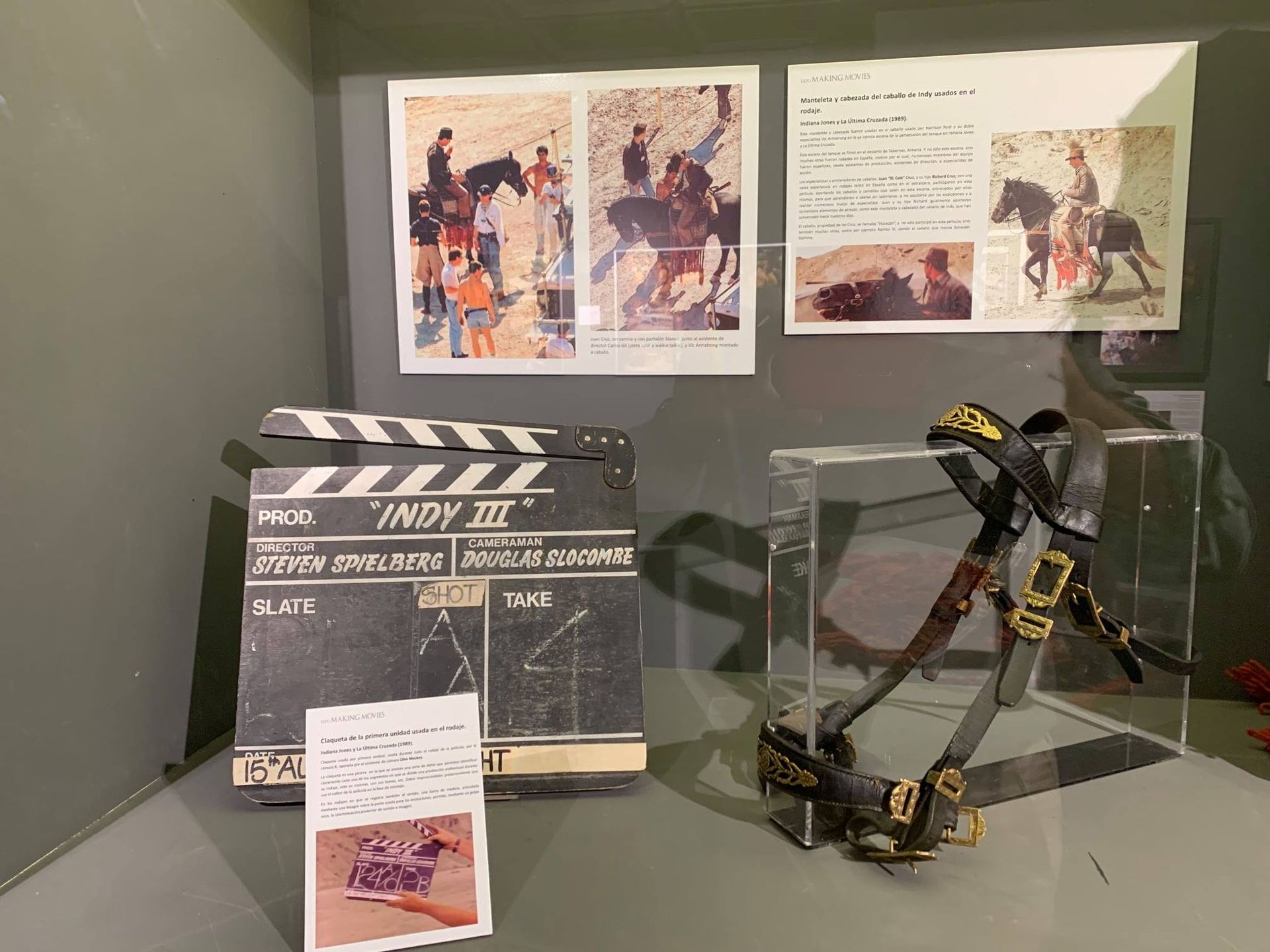 Una claqueta y un trípode se exponen en una vitrina.