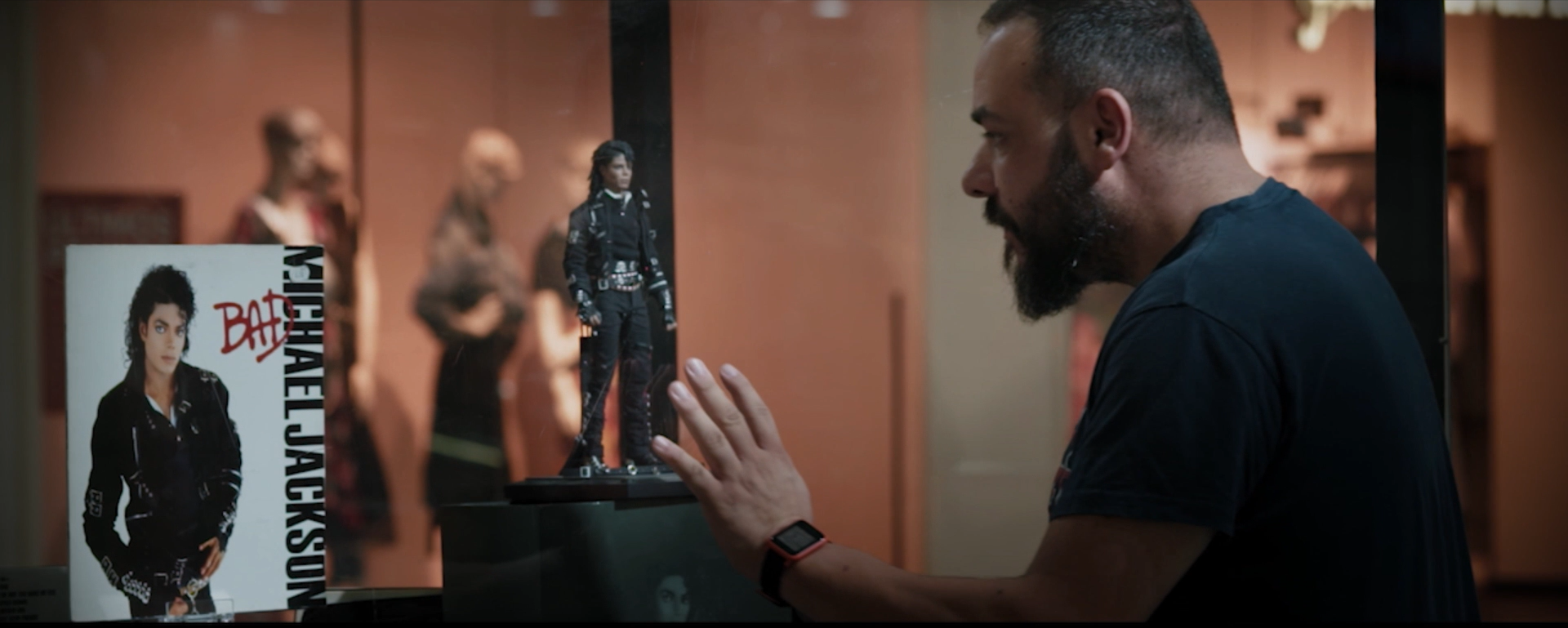 Un hombre está mirando una estatua de Michael Jackson en un museo.