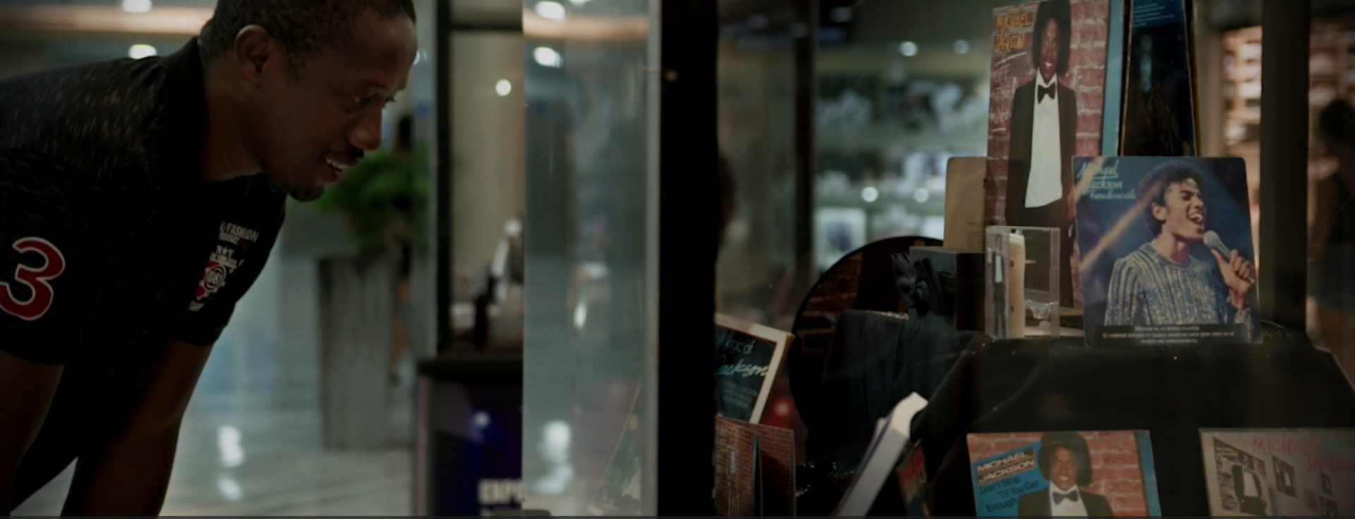 Un hombre está mirando una vitrina de libros en una tienda.