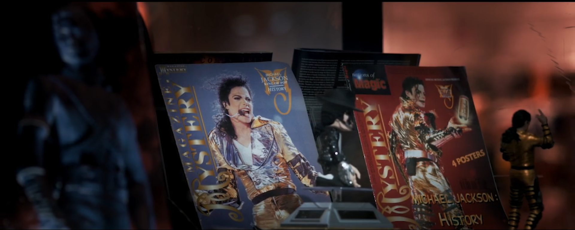 Un montón de fotografías de Michael Jackson están sobre una mesa.