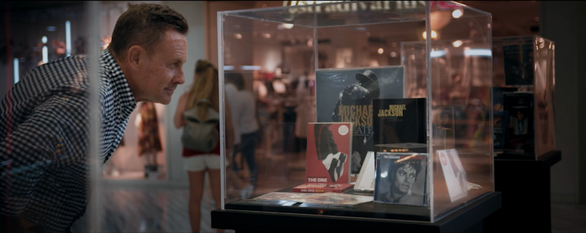 Un hombre está mirando una vitrina en un museo.