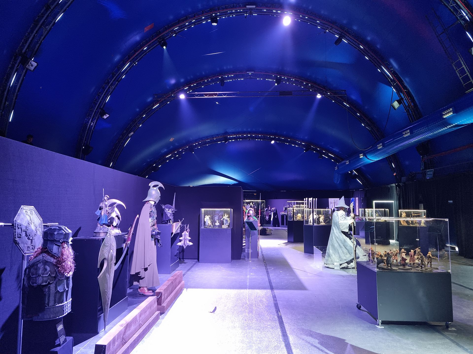 Una gran sala con un techo azul y muchas exhibiciones.