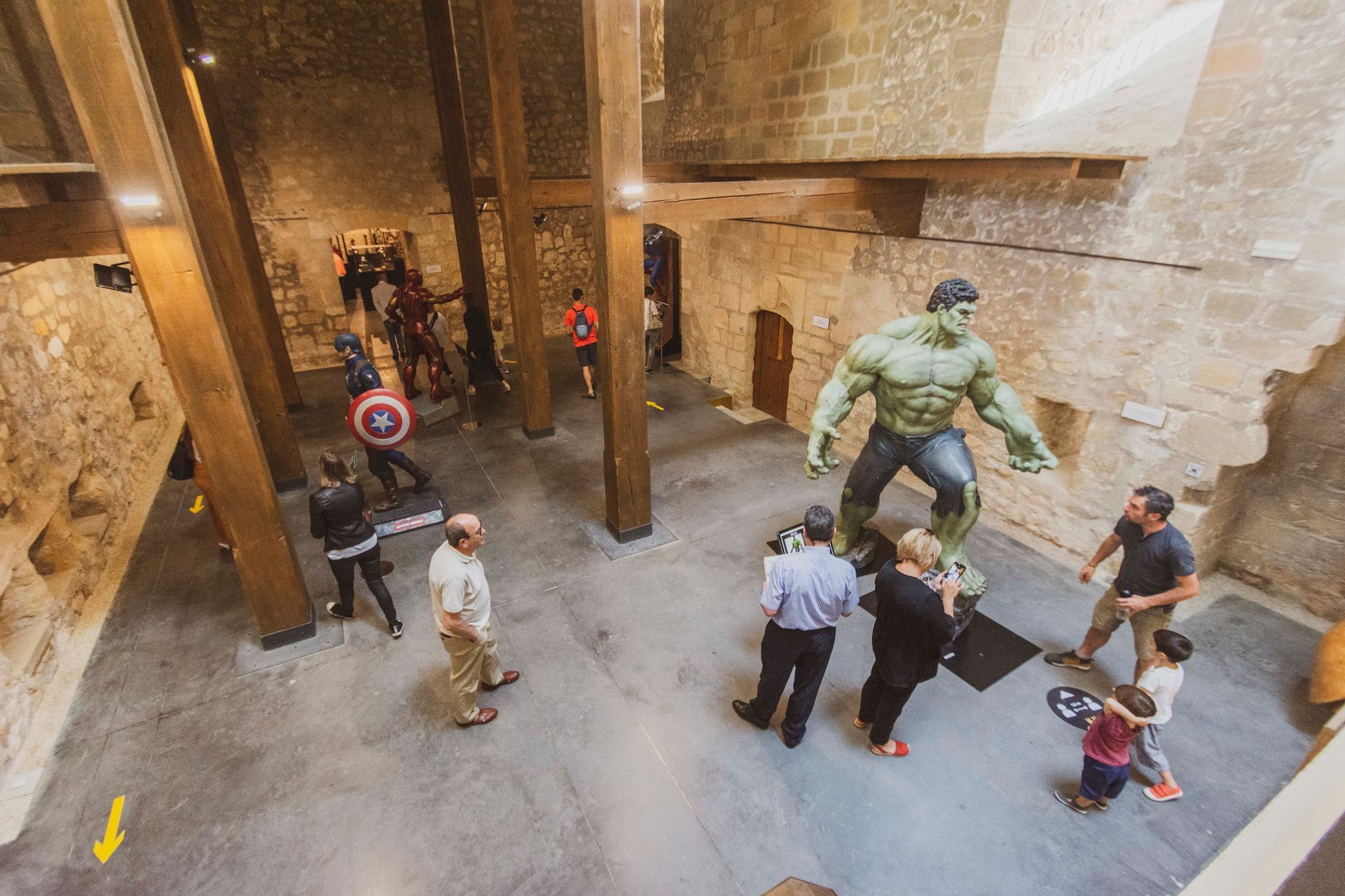 Un grupo de personas está de pie alrededor de una estatua de Hulk.