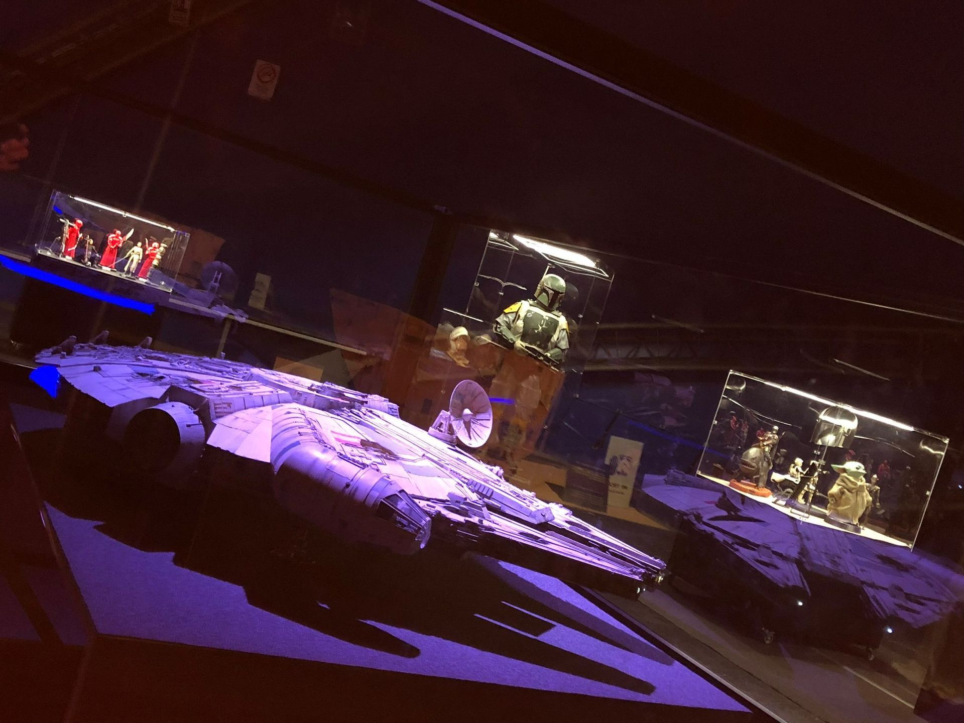 Una estatua de un hombre está sentada en una mesa en una habitación oscura.