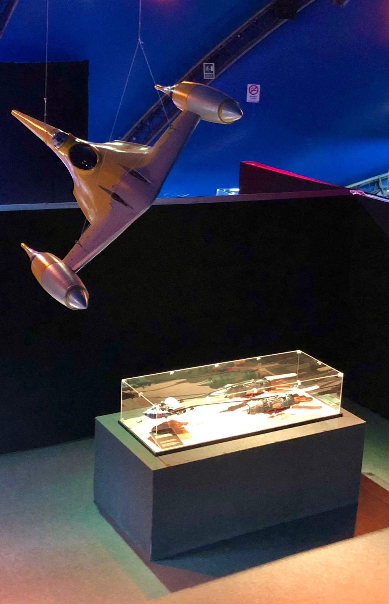 Un modelo de avión cuelga del techo encima de una vitrina.