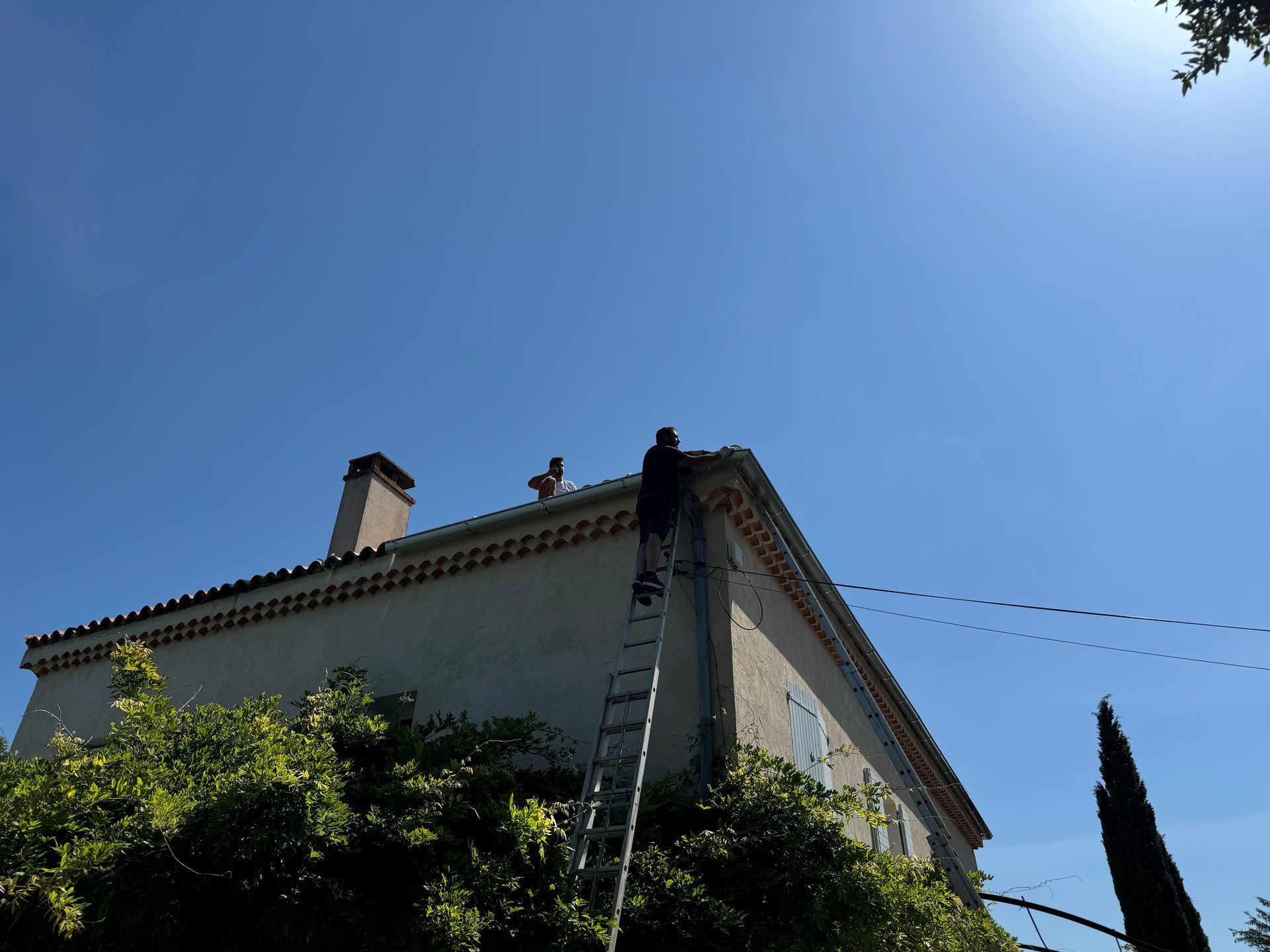 Travaux en haut d'une échelle sur une toiture