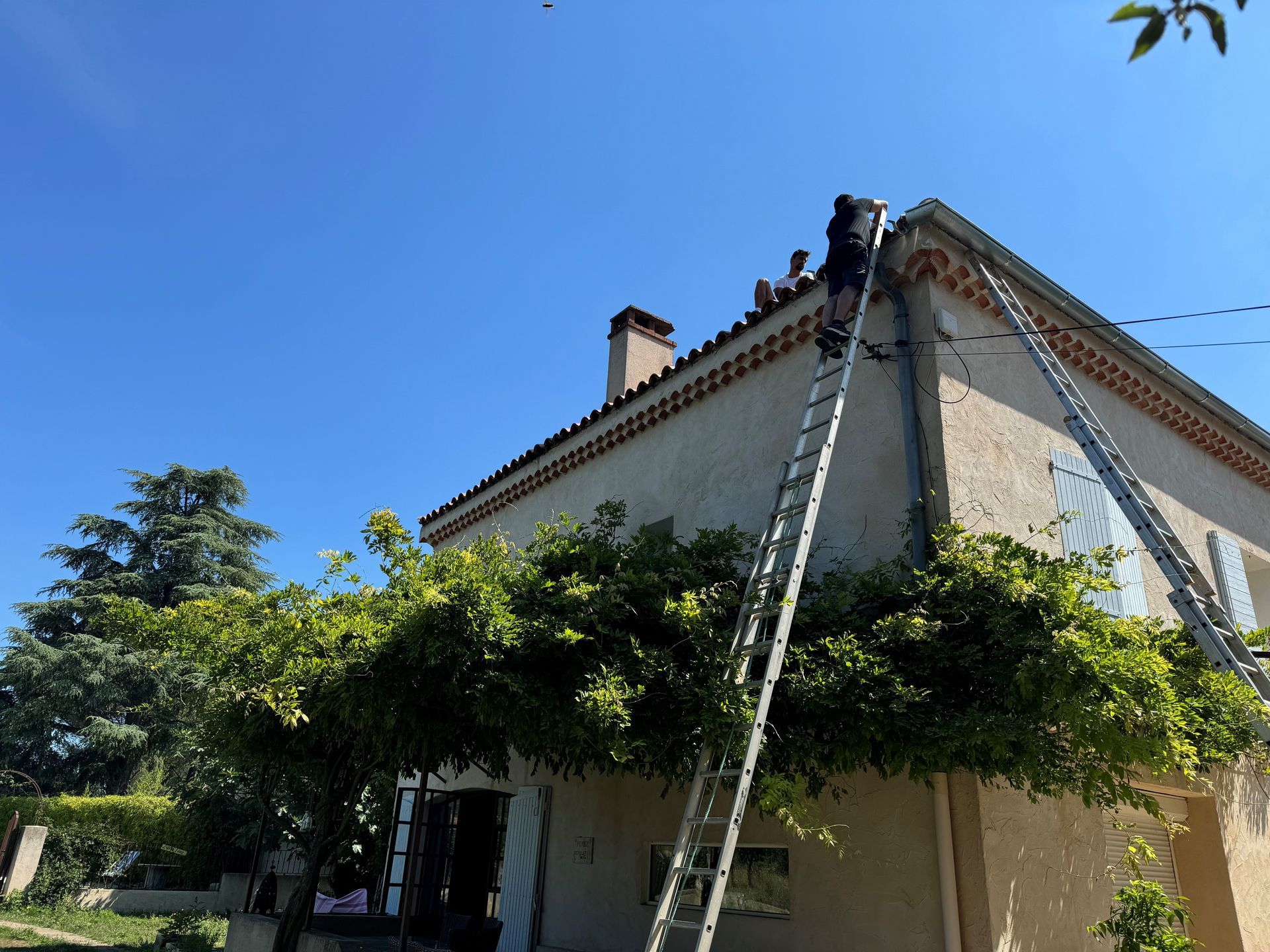 Artisan en haut d'une échelle pour réparer le toit