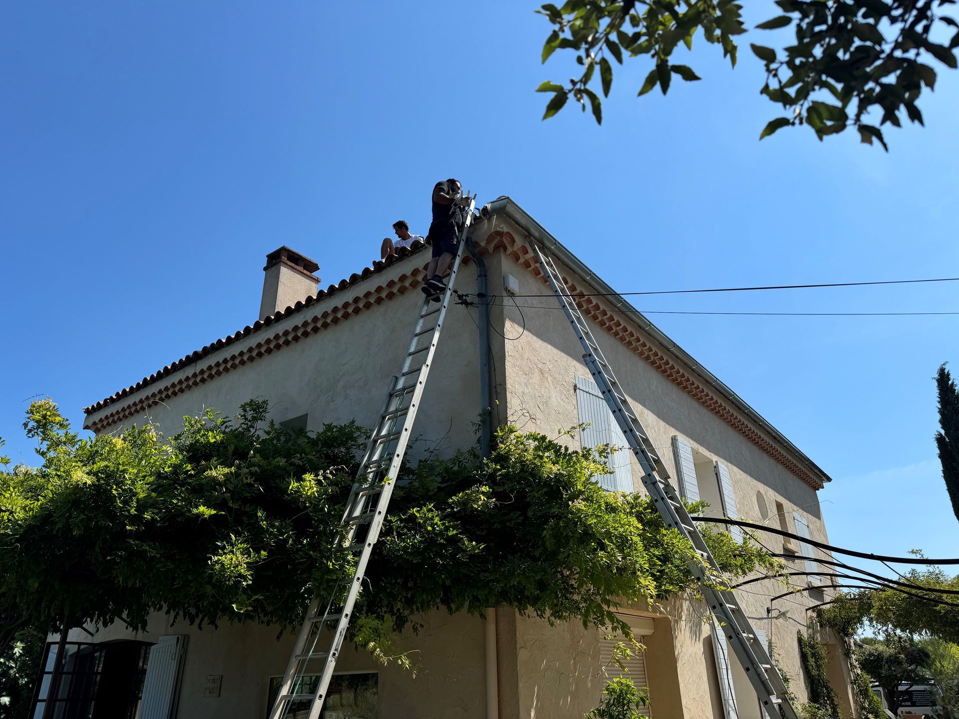 Artisan en haut d'une échelle pour intervenir sur le toit