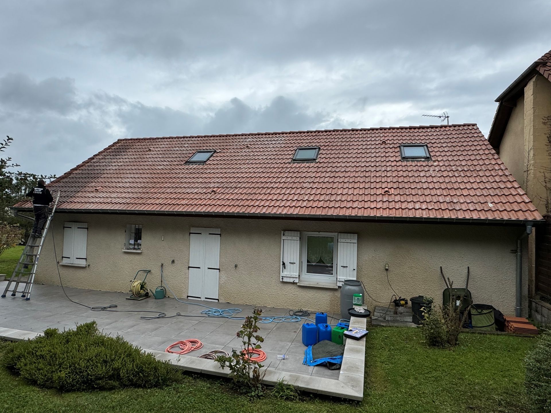 Un couvreur en train de nettoyer une toiture