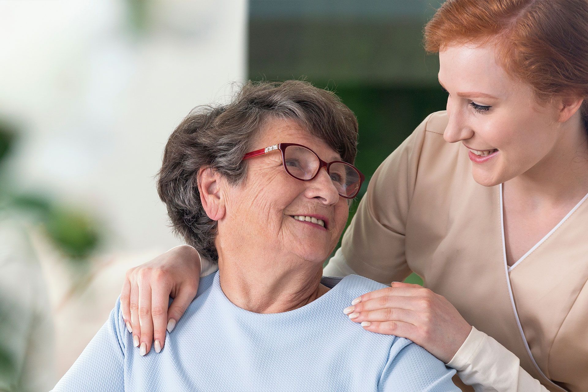 Eine Frau legt ihren Arm um die Schulter einer älteren Frau.