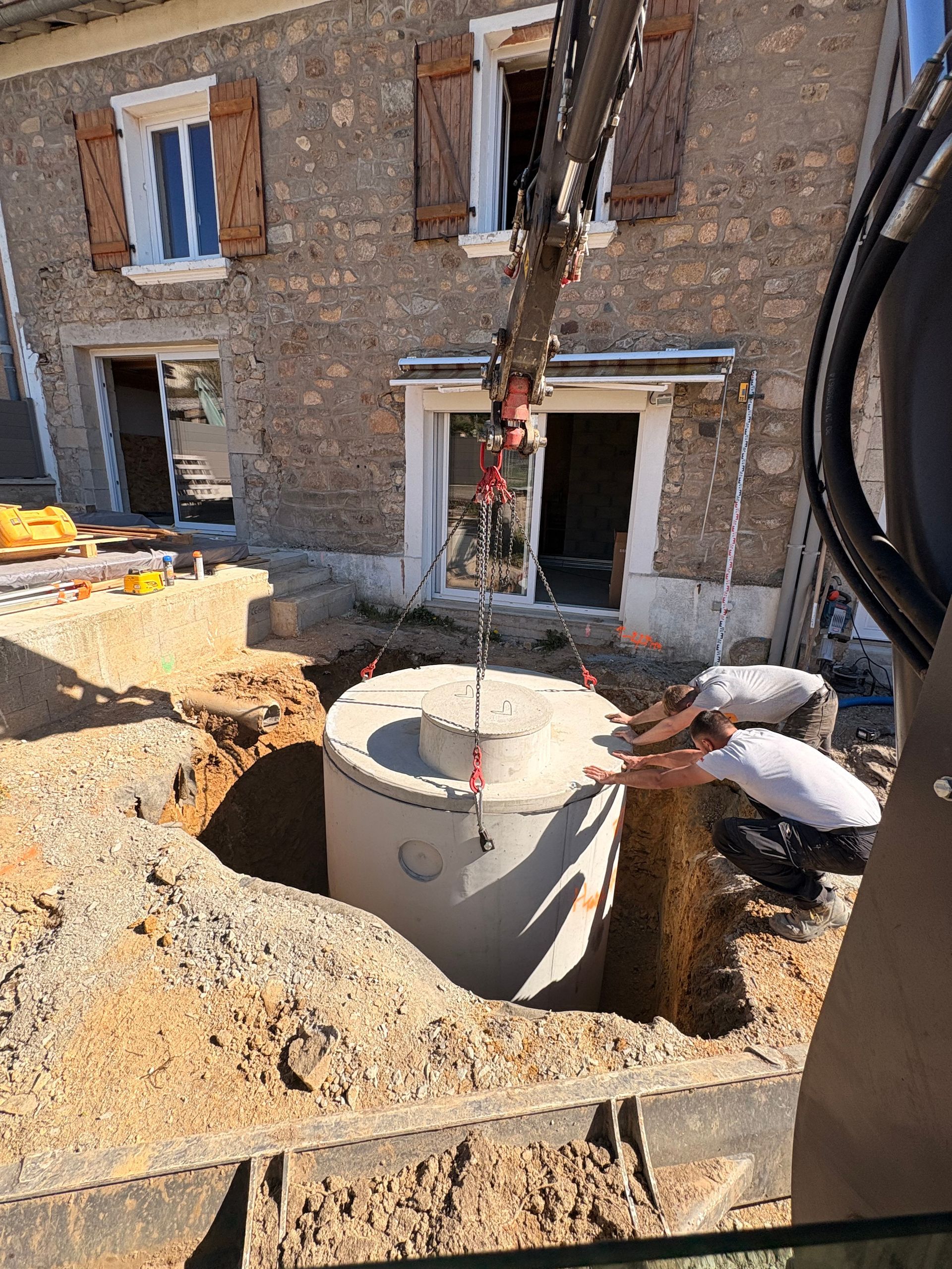 Deux plaques d'égout vertes sur socles en béton dans un parc gazonné, au bord d'un chemin de briques.