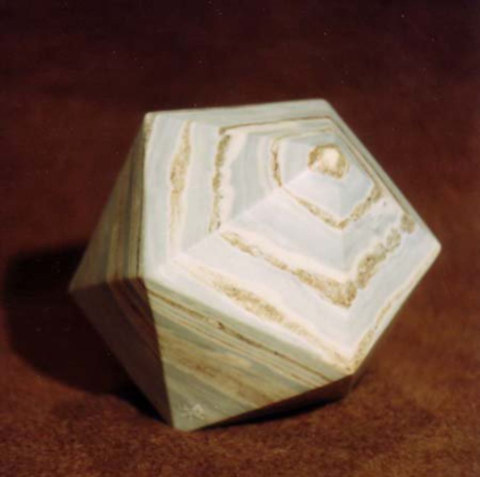 Fünfeckige Skulptur ähnlich einem Kreisel aus hellem Naturstein