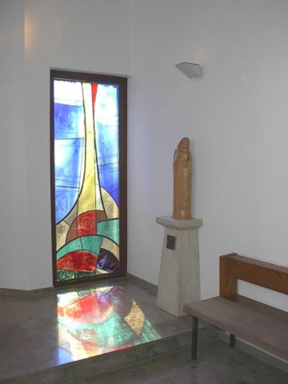 Steinstatue in einem Raum mit buntem Fenster