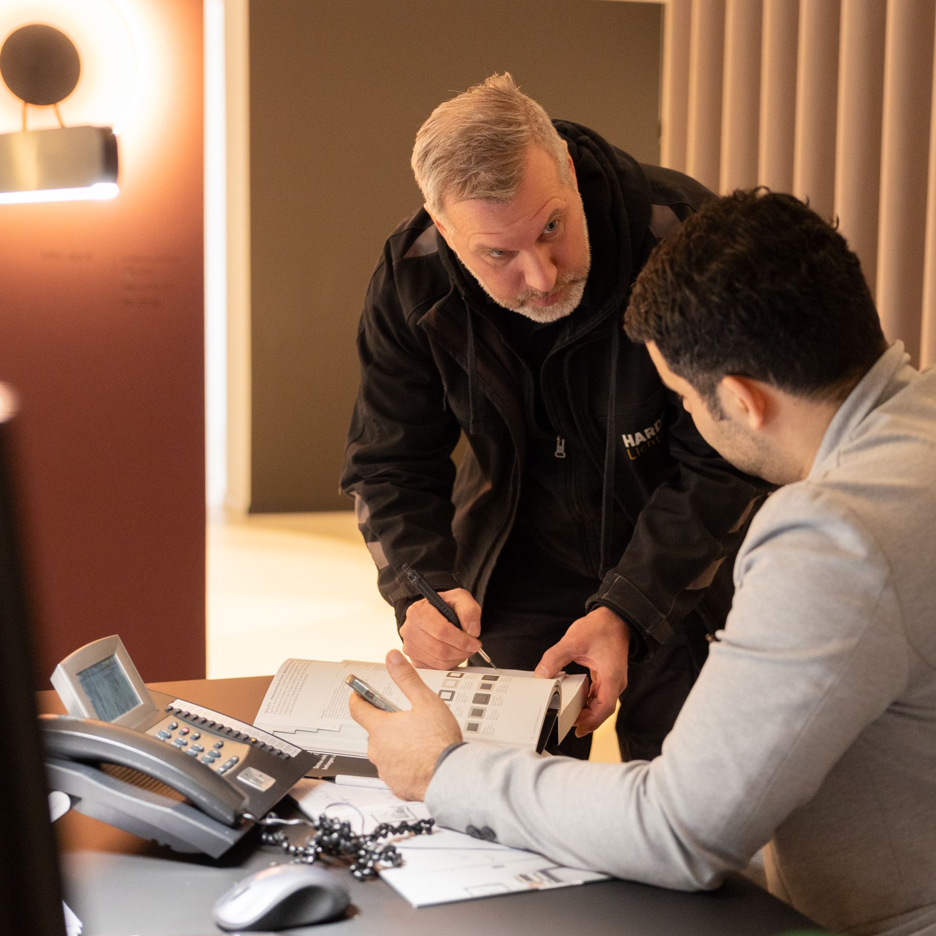 Ein Mann in einer schwarzen Jacke schaut sich ein Buch an