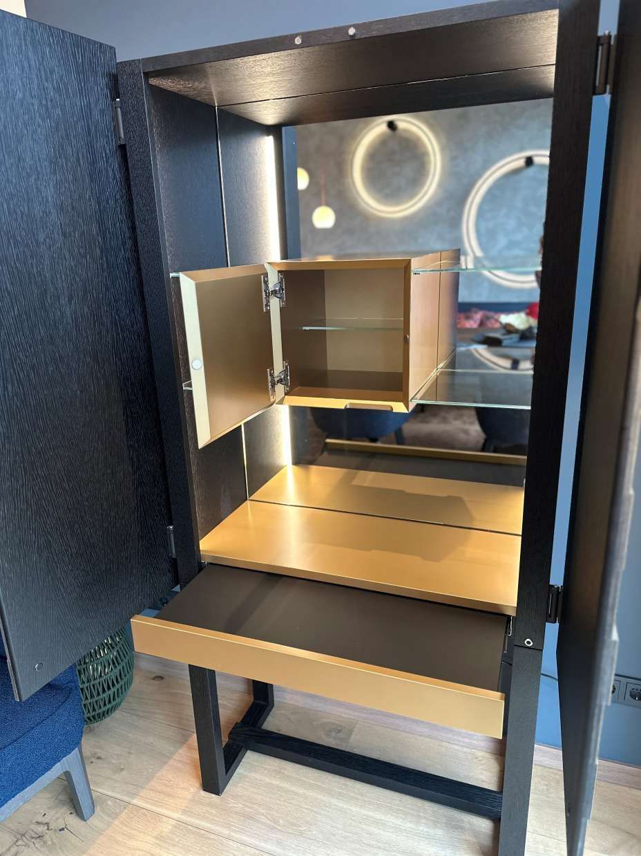 Ein Schrank mit offenen Türen und einem Regal darin.