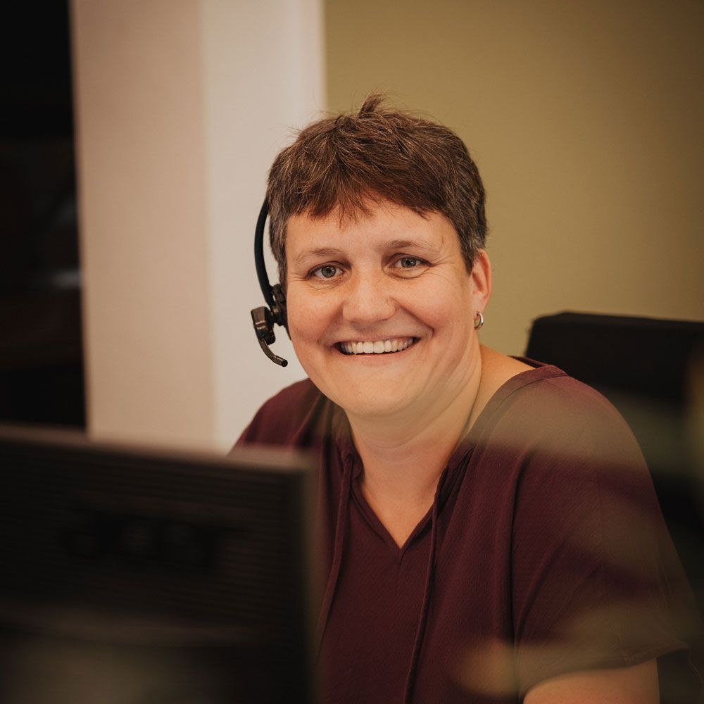 Eine Frau mit Headset sitzt vor einem Acer-Computermonitor