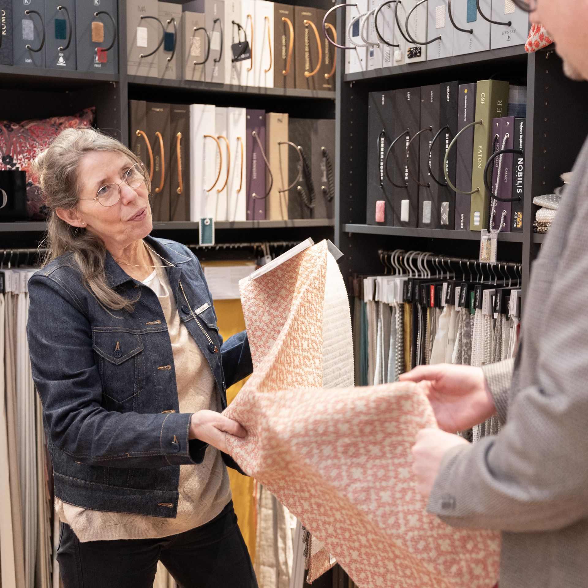 Eine Frau in einer Jeansjacke hält ein Stück Stoff