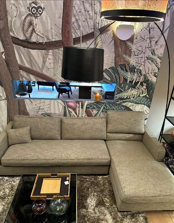Ein Wohnzimmer mit Sofa, Couchtisch, Lampe und Gemälde an der Wand.