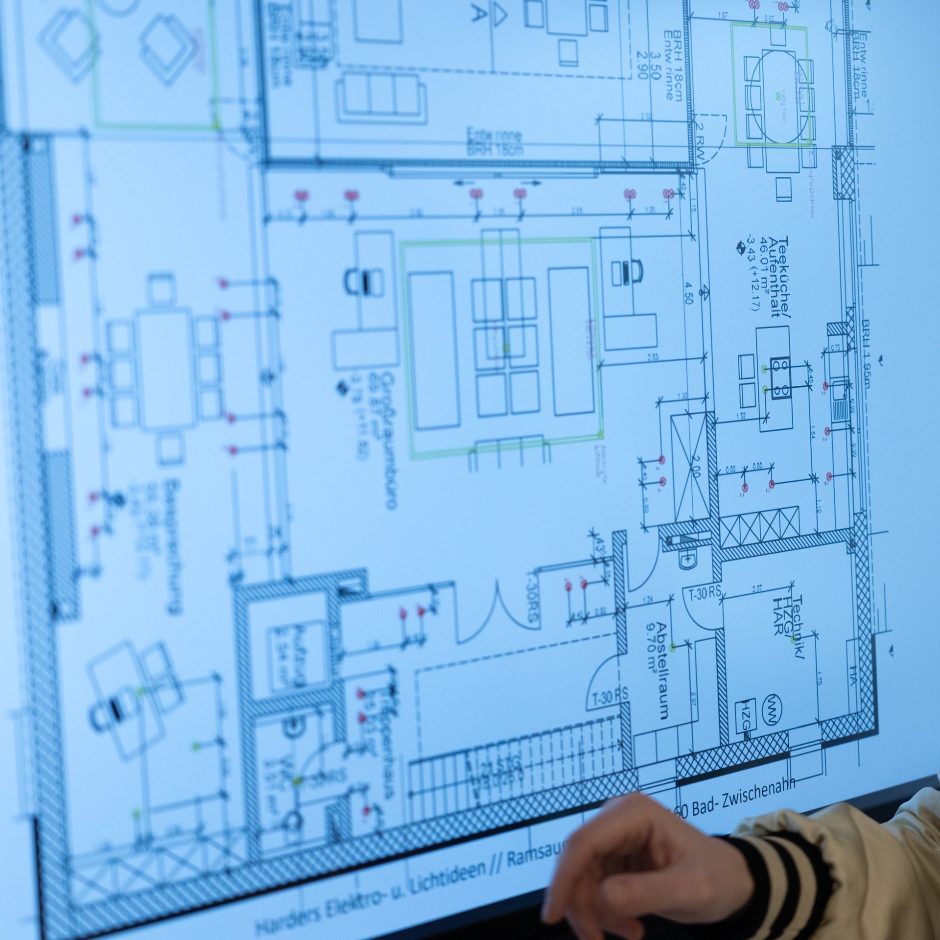 Eine Person zeigt auf einen Grundriss eines Hauses