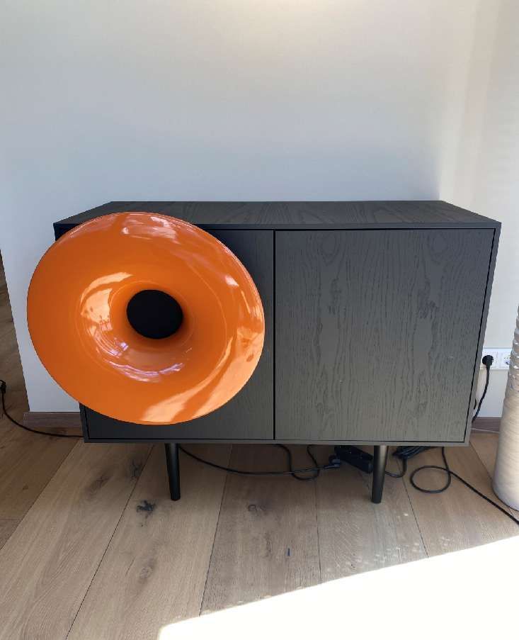 Ein schwarzer Schrank mit einem großen orangefarbenen Kreis an der Seite