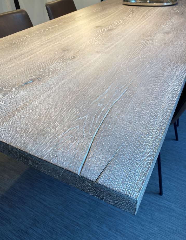Eine Nahaufnahme eines Holztischs mit Stühlen in einem Raum.