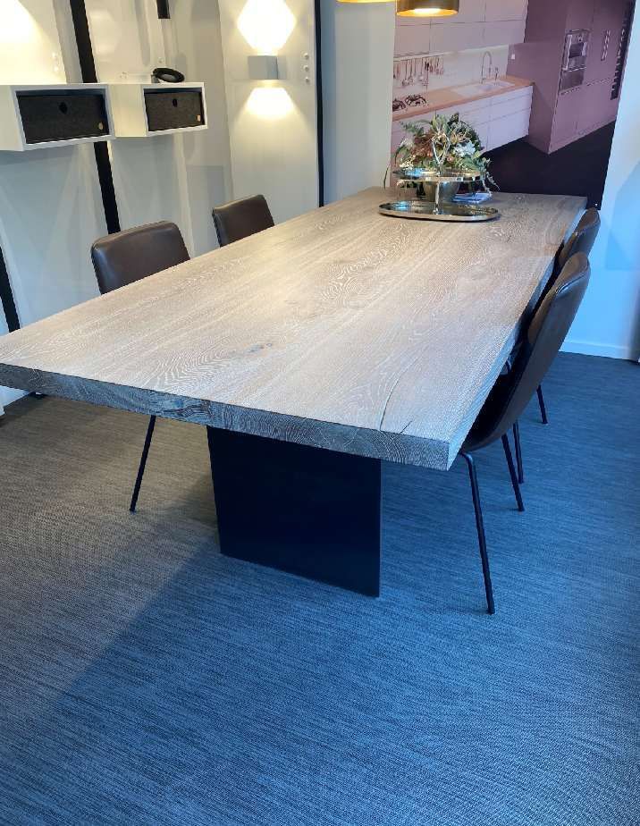 Ein großer Holztisch mit Stühlen in einem Raum.