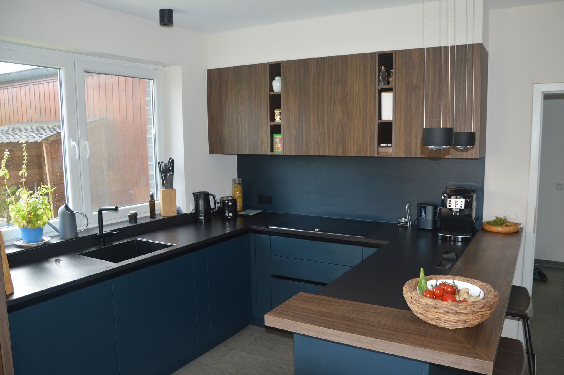 Eine Küche mit blauen Schränken und schwarzen Arbeitsplatten