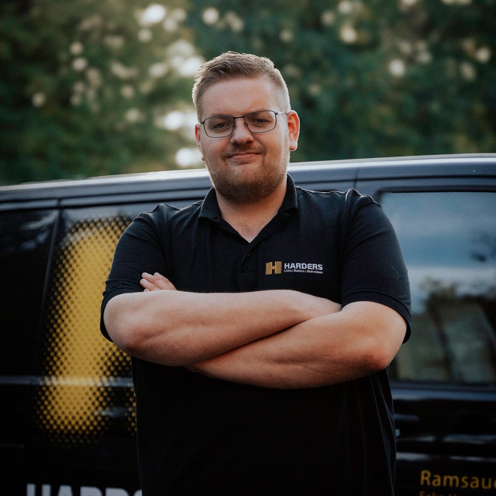 Ein Mann in einem schwarzen Hemd mit der Aufschrift „Harders“ darauf