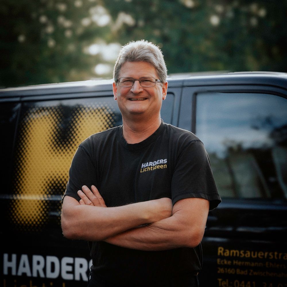 Ein Mann steht vor einem Lieferwagen, auf dem „Härter“ steht