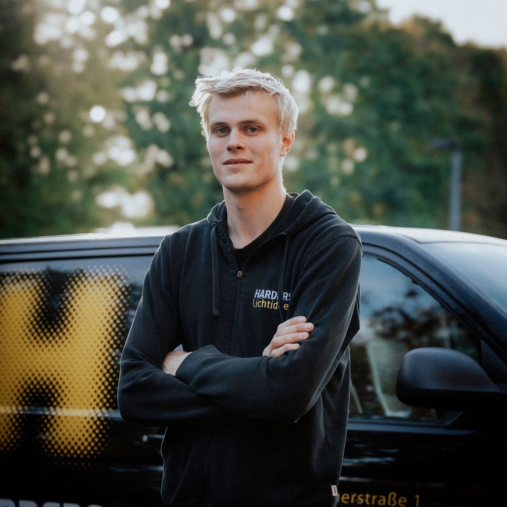 Ein Mann in einem schwarzen Hemd mit der Aufschrift „Harders“ darauf