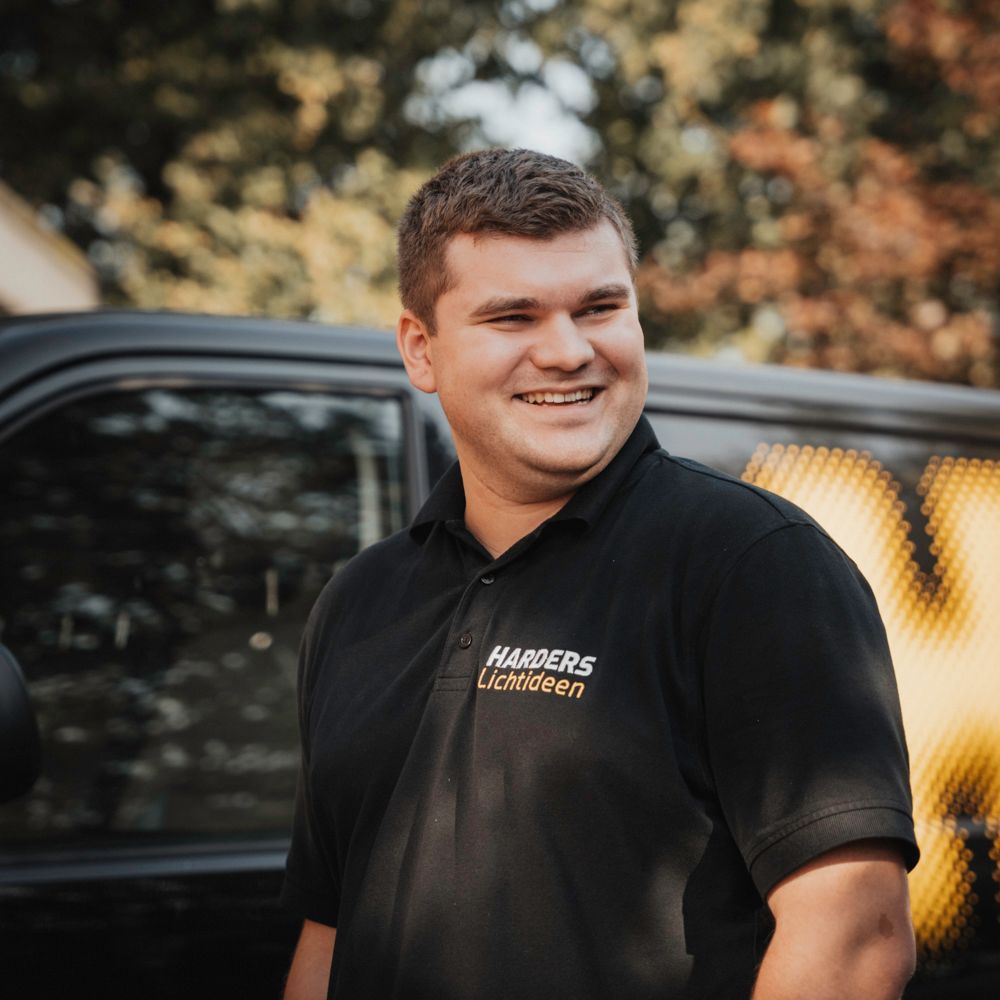 Ein Mann in einem schwarzen Hemd mit der Aufschrift „Harders“ darauf