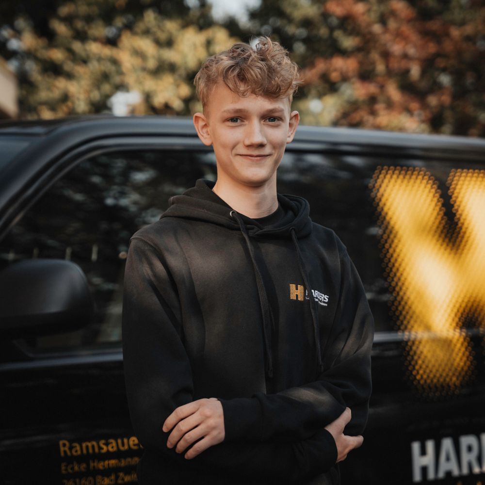 Ein Mann in einem schwarzen Hemd mit der Aufschrift „Harders“ darauf