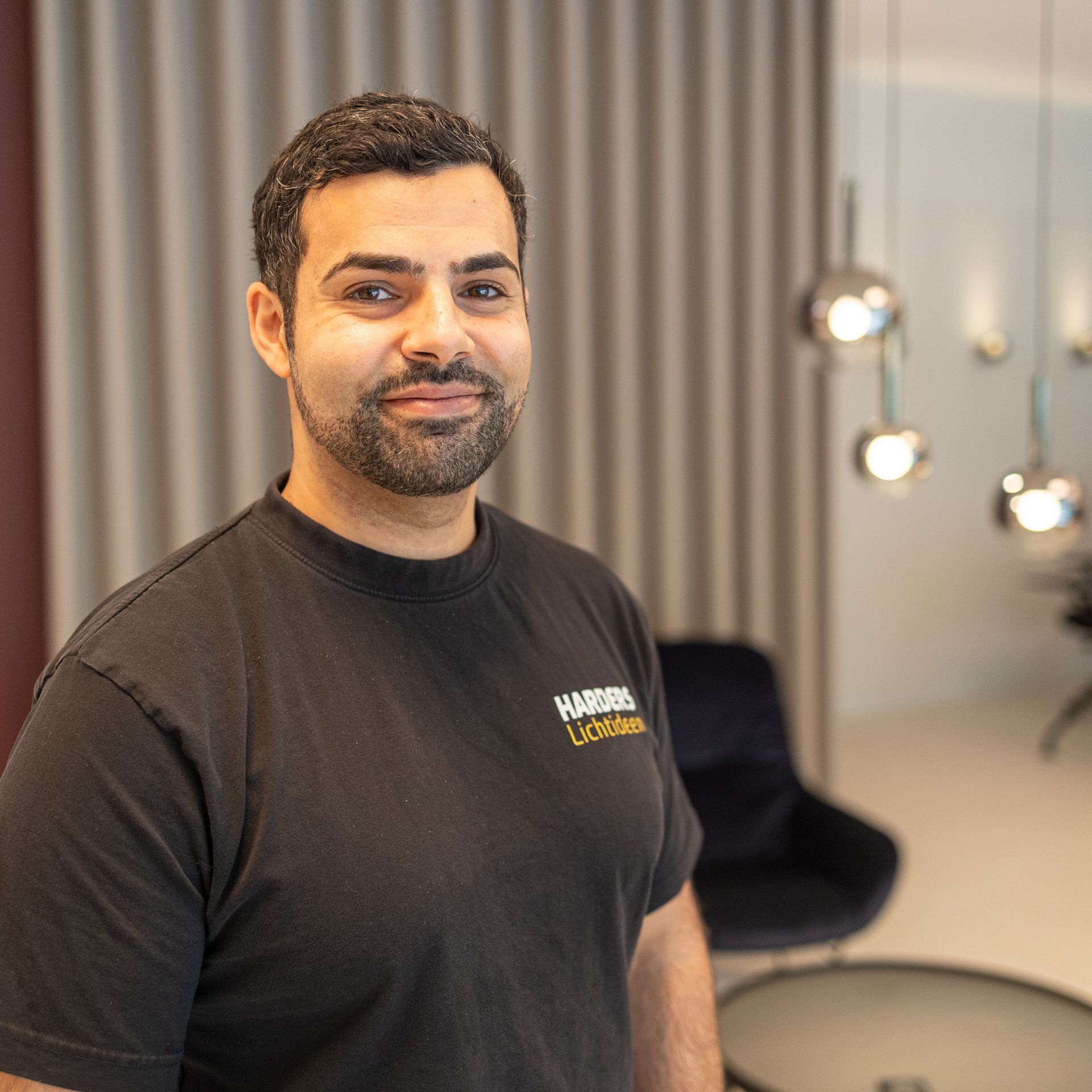 Ein Mann mit Bart trägt ein schwarzes T-Shirt mit der Aufschrift „Harders“