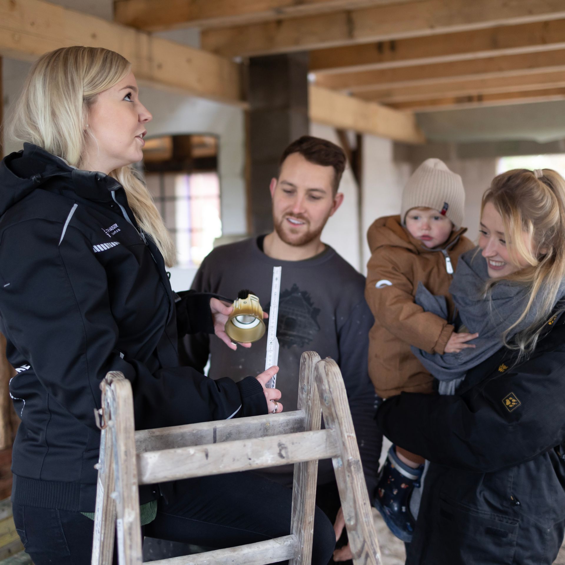 Eine Gruppe von Menschen steht um eine Holzleiter herum