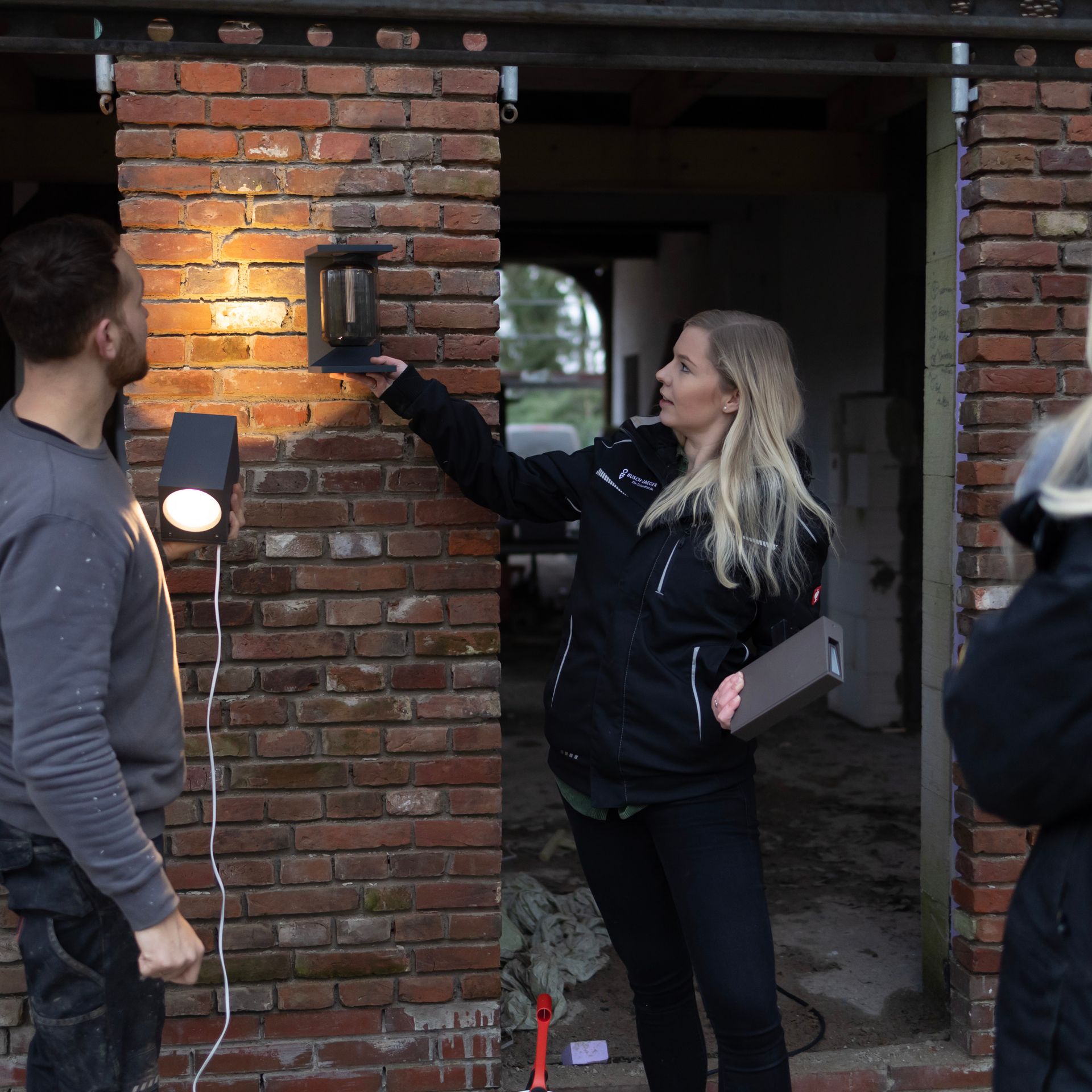 Ein Mann und eine Frau stehen vor einer Backsteinmauer
