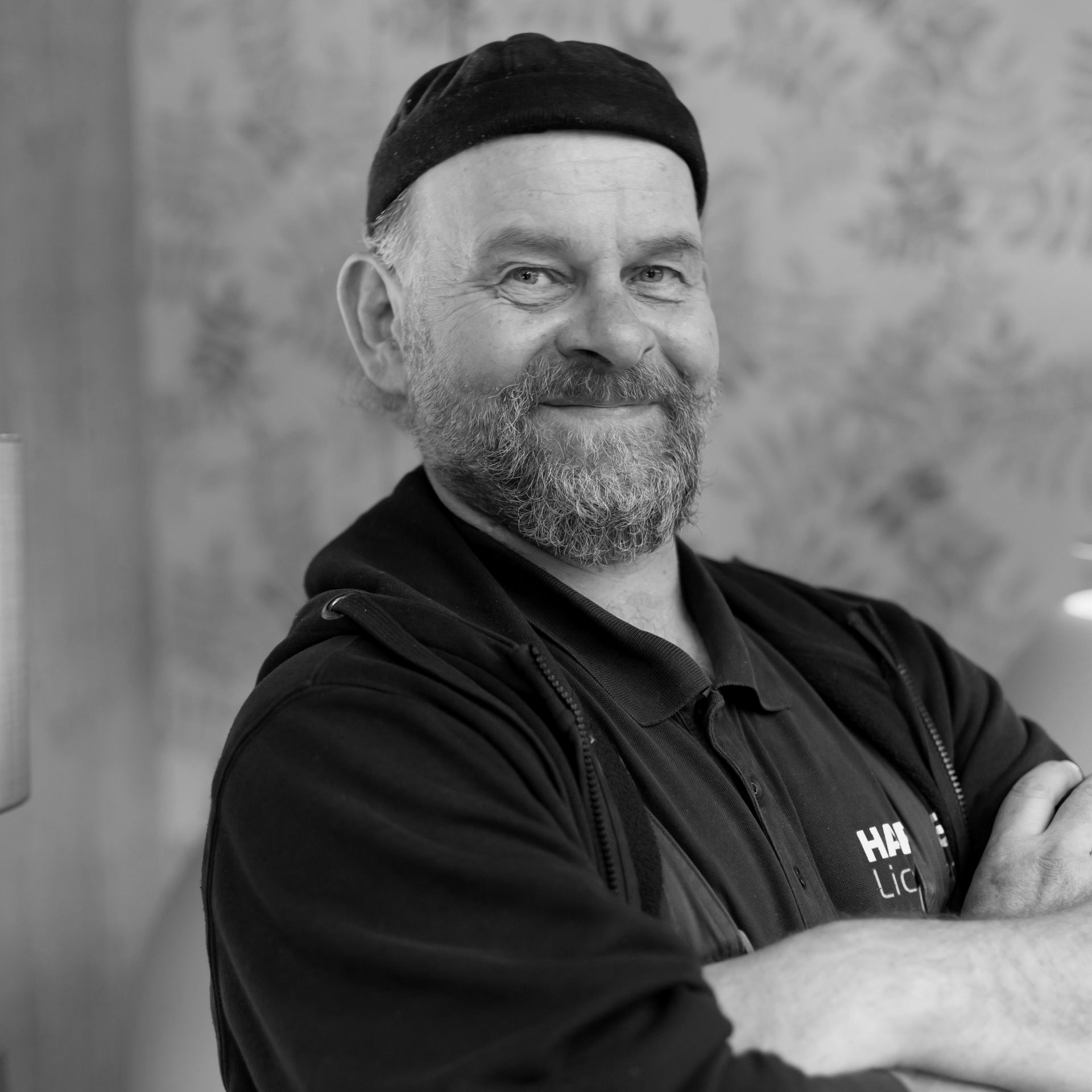 Ein Mann mit Bart und einem schwarzen T-Shirt mit der Aufschrift „Harders“