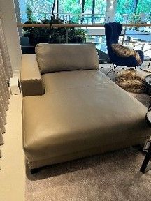 In einem Wohnzimmer steht eine Chaiselongue aus beigefarbenem Leder.