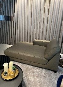 Eine Chaiselongue steht in einem Wohnzimmer neben einem Couchtisch.