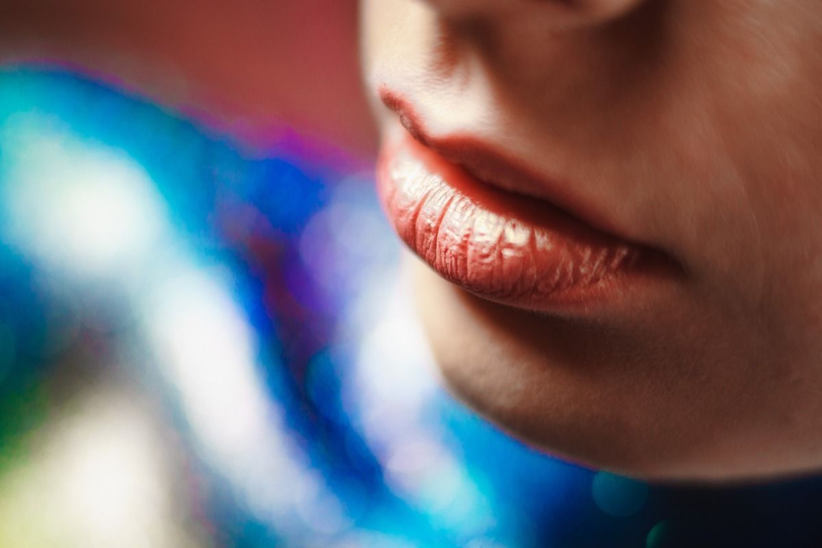 Un primer plano de los labios de una mujer con lápiz labial rojo.