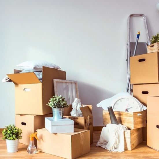 Un montón de cajas de cartón están apiladas una encima de otra en una habitación.