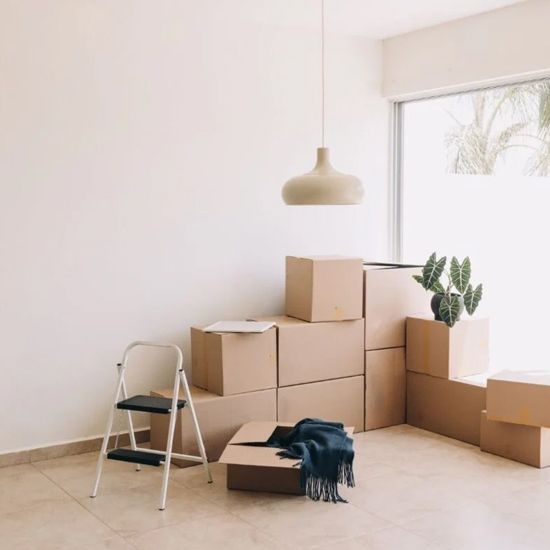 Una habitación llena de cajas de cartón y una escalera