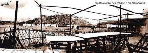 Una foto en blanco y negro de un restaurante con mesas y sillas.