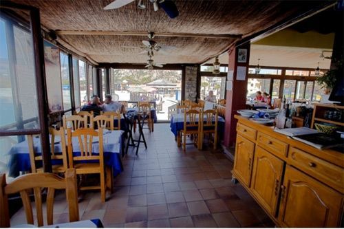 Un restaurante con mesas y sillas y un mostrador.