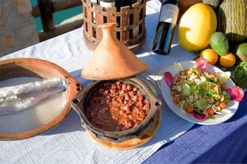 Una mesa cubierta con platos de comida y una botella de vino.