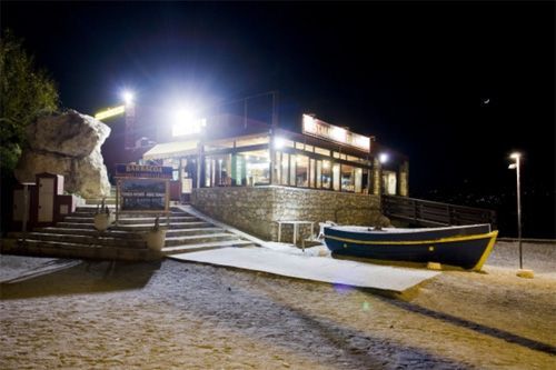 Un barco está atracado frente a un edificio por la noche.