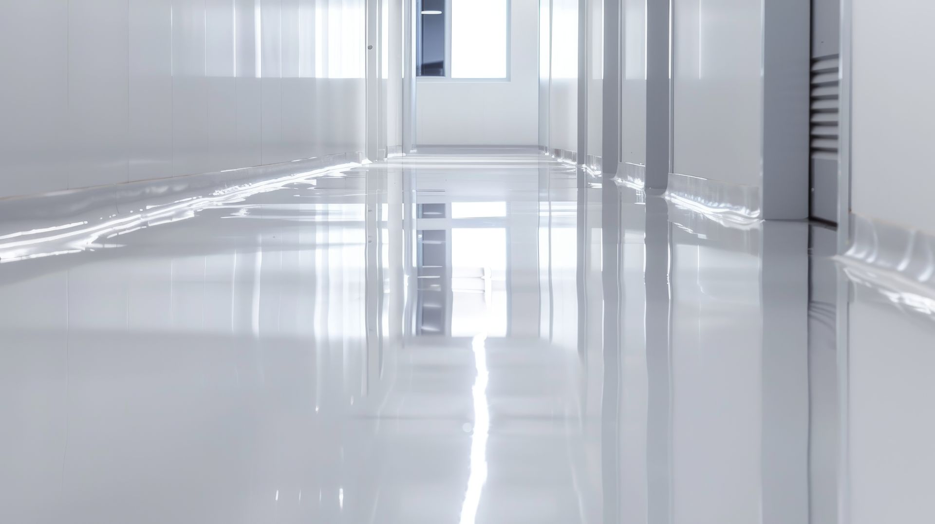 Couloir blanc lumineux et vide, avec un sol brillant et réfléchissant et des fenêtres au fond.