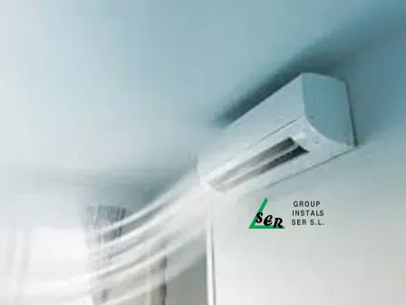 Aire acondicionado soplando aire en el interior, montado en una pared blanca.