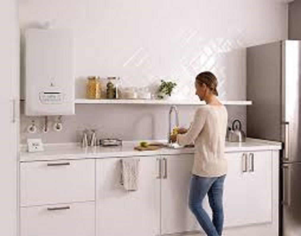 Mujer en el fregadero de la cocina; gabinetes blancos, calentador de agua, preparación de alimentos, brillante.