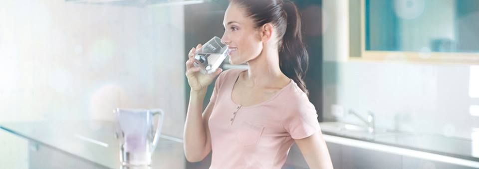 Arquitectos colaborando alrededor de una mesa con planos, tabletas, computadoras portátiles y cascos.